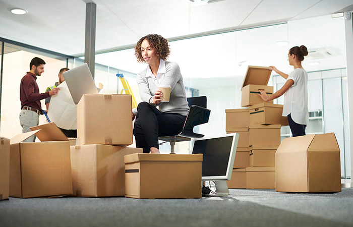 Woman in office surrounded by boxes