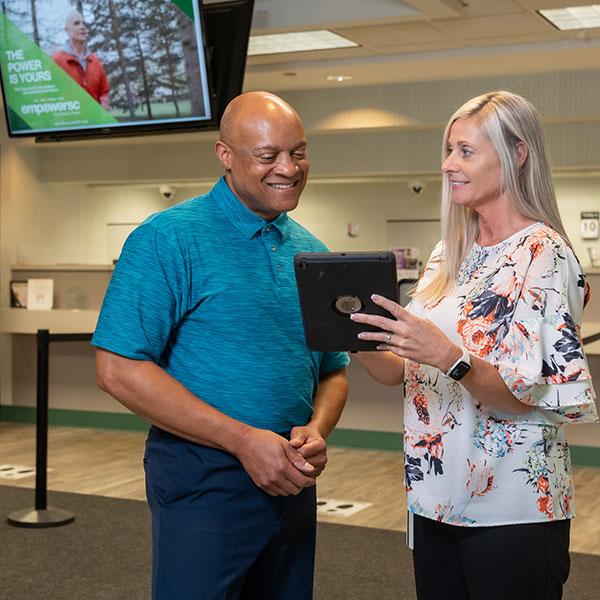 woman shows man something on a tablet